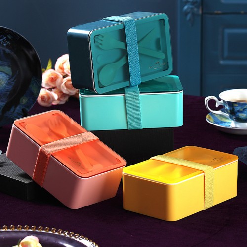 Lonchera tipo bento box con cierre elástico y compartimentos internos. Incluye cubiertos y está disponible en varios colores elegantes VENTA AL POR MAYOR 475LU