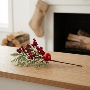 Pick decorativo navideño de 39 cm con bayas rojas y follaje, ideal para complementar árboles, coronas y arreglos festivos. Venta por mayoreo