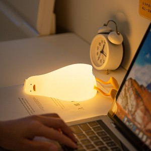 Lámpara kawaii con forma de pato, de silicona. Emite luz LED, ideal como luz nocturna para recámara infantil, escritorio o decoración. Venta por mayoreoRSD-451